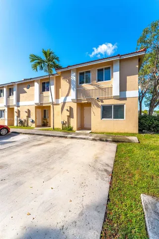 a front view of a house with a garden and yard
