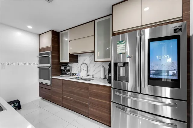 a kitchen with stainless steel appliances granite countertop a refrigerator and a sink