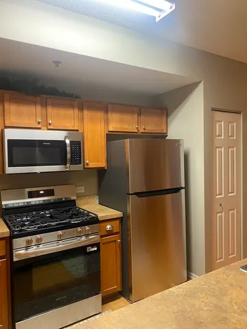 a kitchen with stainless steel appliances a refrigerator stove and microwave