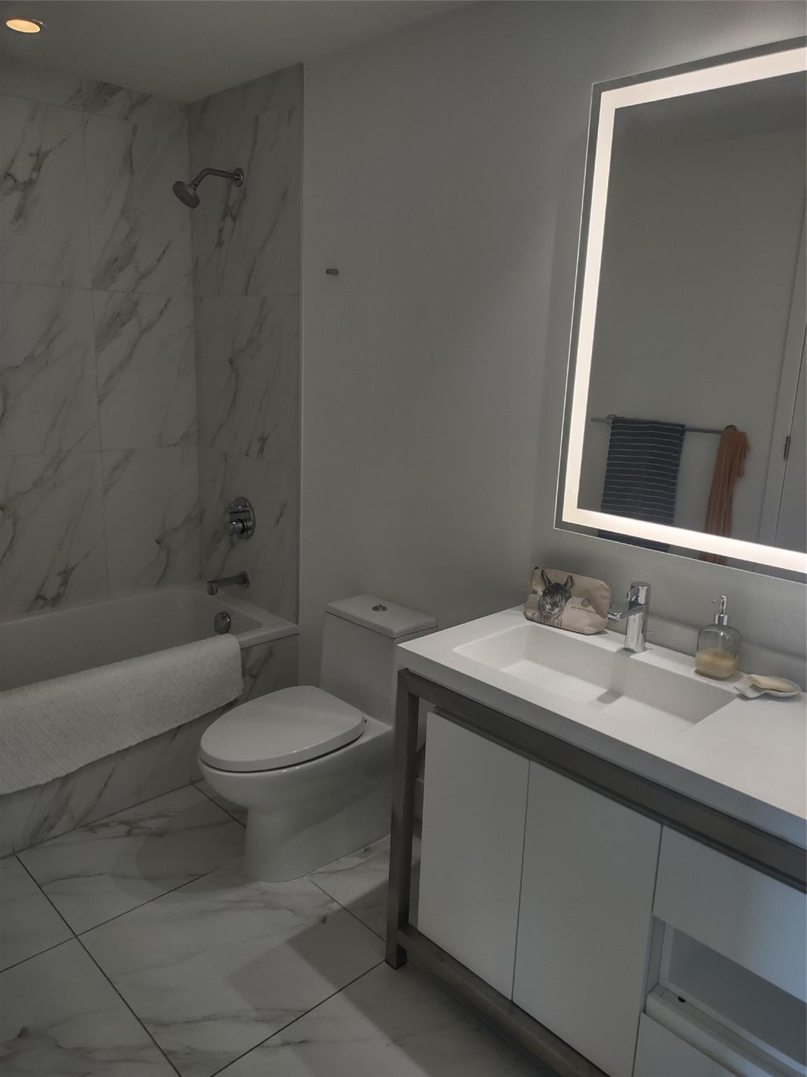 2000 Metropica Way, Unit 507 Sunrise, FL 33323 - Photo 13 of 13 a bathroom with a granite countertop toilet sink mirror and shower