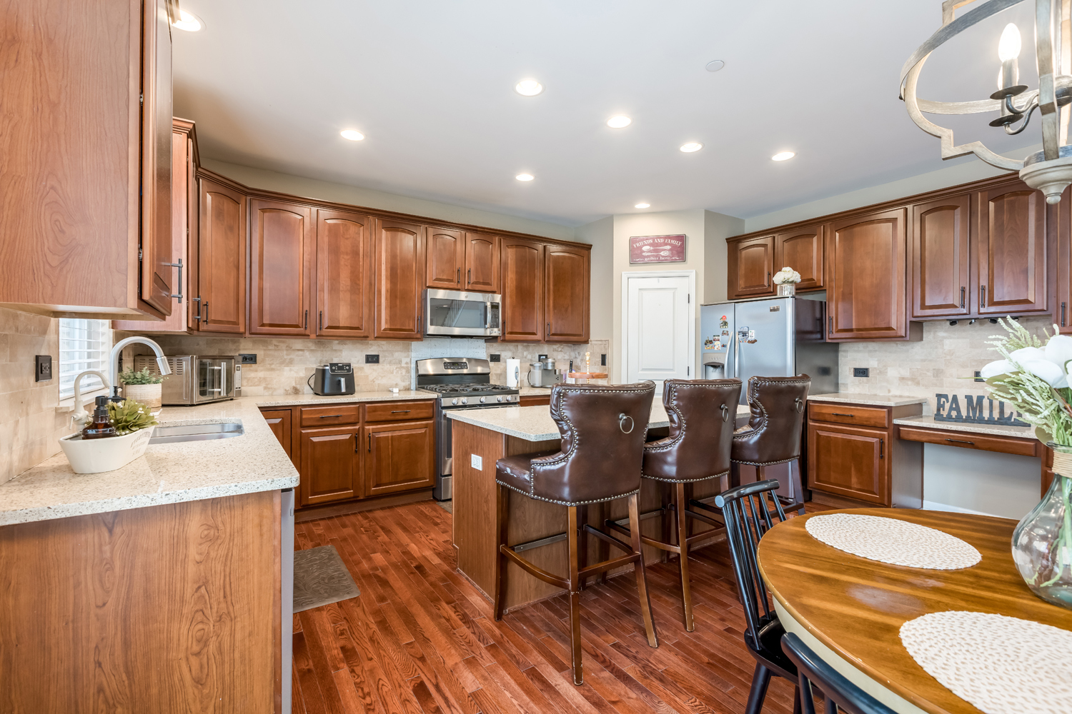 908 Blue Ridge Drive Streamwood, IL 60107 - Photo 13 of 48 a kitchen with kitchen island granite countertop wooden floors wooden cabinets a center island and appliances