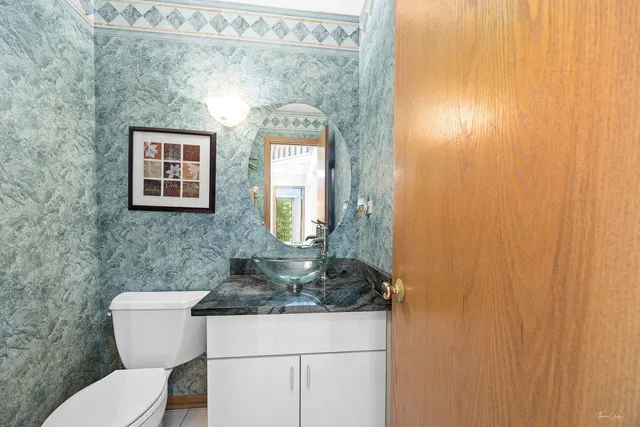 a bathroom with a toilet a sink and mirror