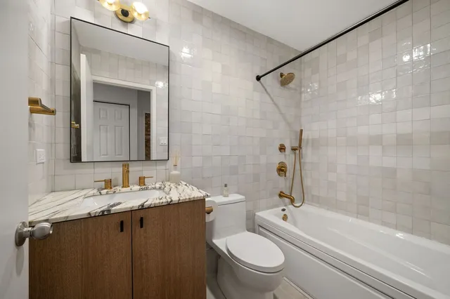 a bathroom with a granite countertop sink toilet and shower