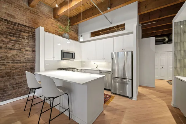 a kitchen with stainless steel appliances a refrigerator and a stove top oven