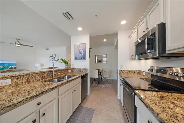 a kitchen with stainless steel appliances granite countertop a sink stove and cabinets