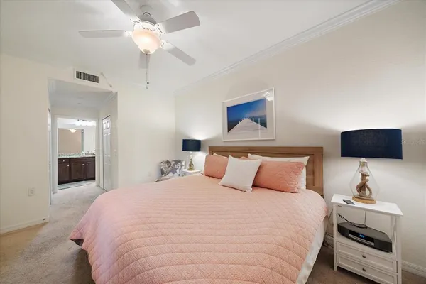 a bedroom with a bed a flat screen tv and a chandelier