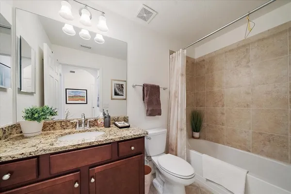 a bathroom with a granite countertop sink toilet and shower
