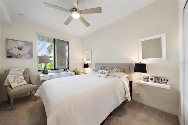 a spacious bedroom with a bed a couch and a ceiling fan