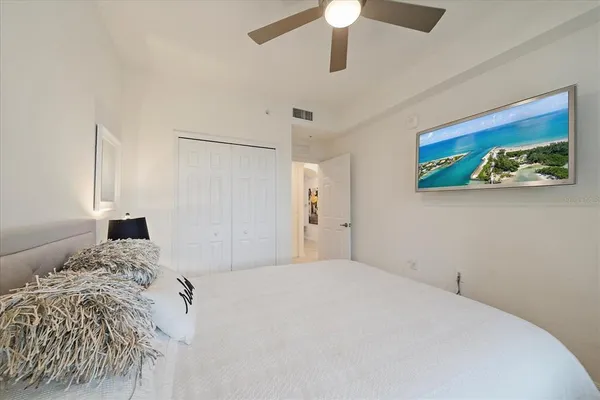 a bedroom with a large bed and a chandelier