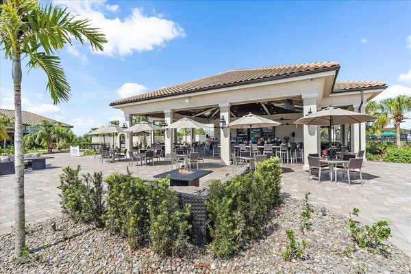 a view of a patio with table and chairs potted plants and palm trees