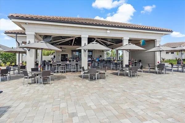 a view of a patio with dining table and chairs under an umbrella