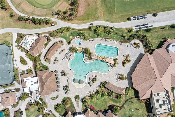an aerial view of ocean and residential houses with outdoor space