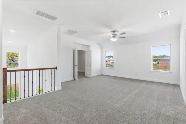 an empty room with fan and windows