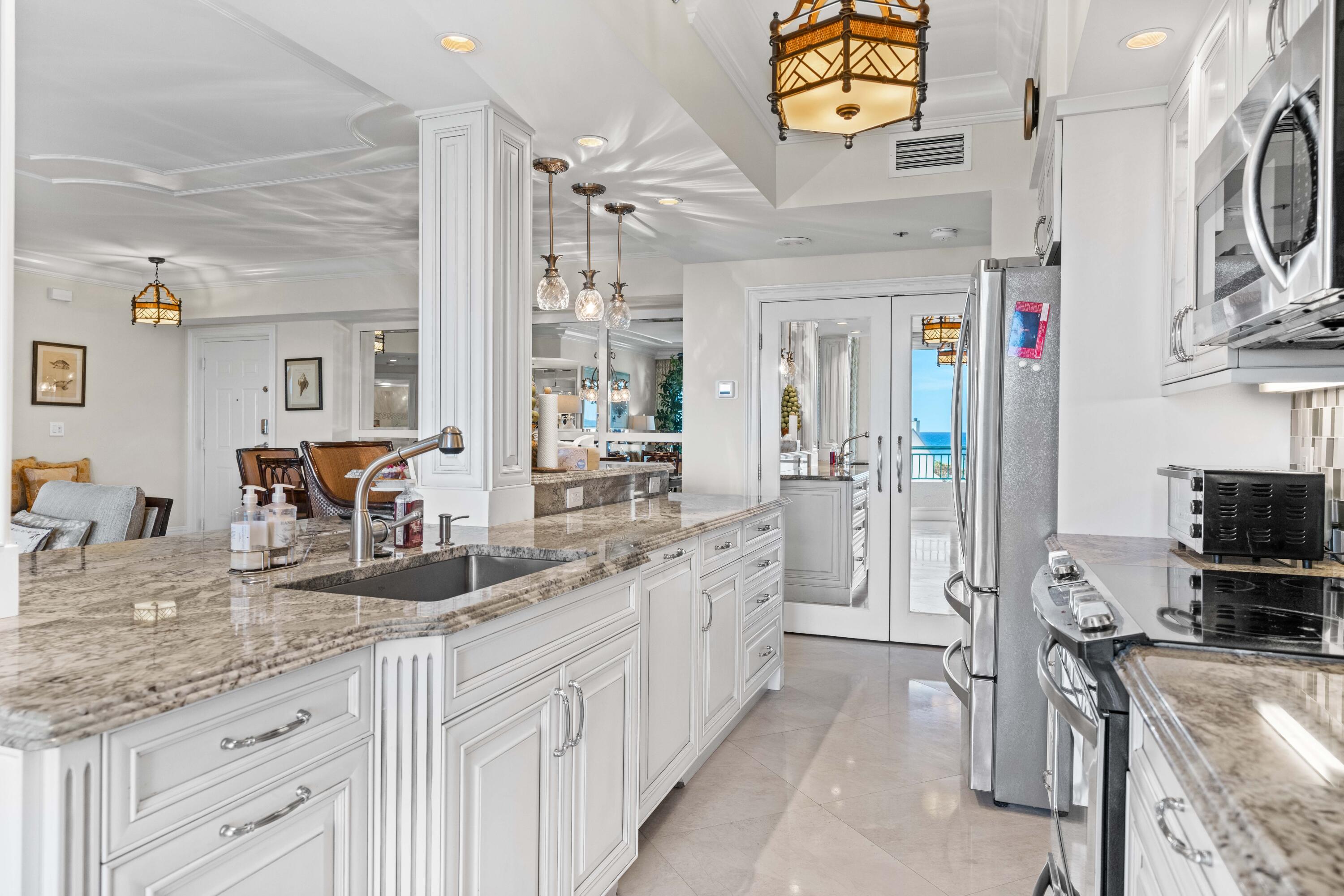 2000 Florida A1A, Unit 406 Jupiter, FL 33477 - Photo 11 of 40 a large kitchen with a lot of counter space and wooden floor