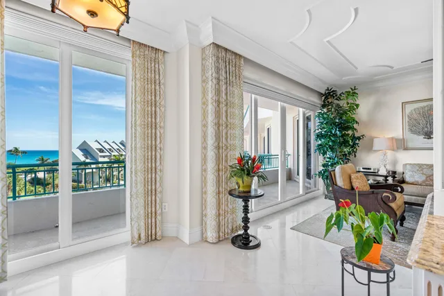 a living room with furniture a large window and wooden floor