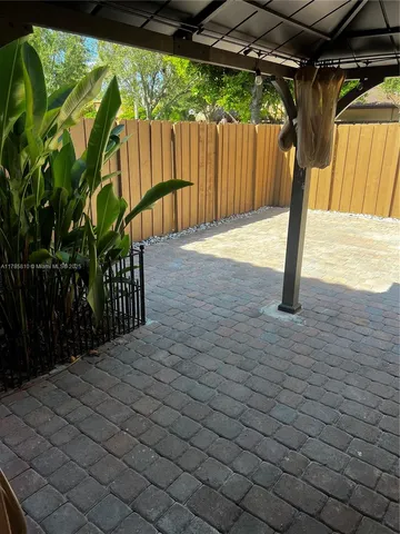 a black and white building with wooden fence