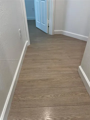 an empty room with wooden floor and door