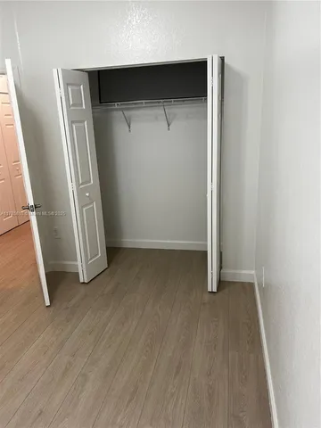 an empty room with wooden floor and door