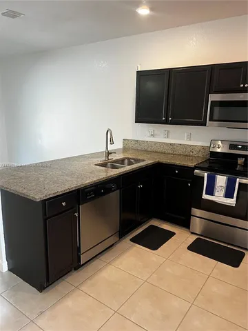 a kitchen with stainless steel appliances granite countertop a sink and a stove