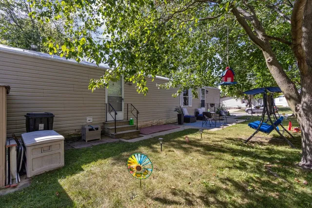 a view of a backyard with couches plants and large trees