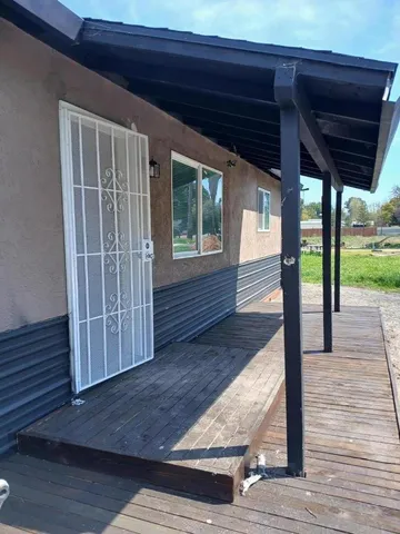 a view of porch with wooden floor and floor to ceiling window