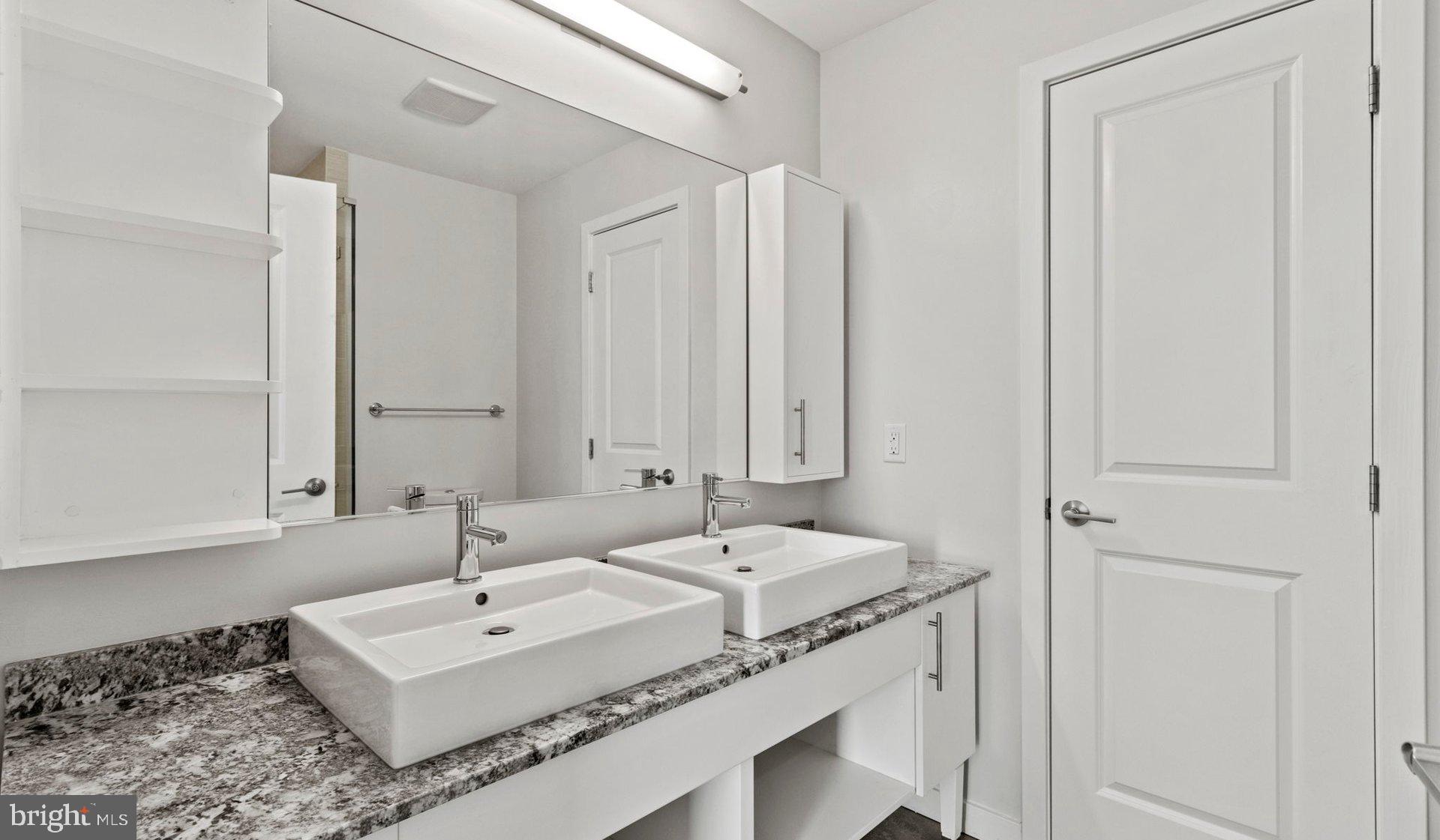 8300 Wisconsin Avenue, Unit 1B1841 Bethesda, MD 20814 - Photo 120 of 150 a bathroom with a sink and a mirror