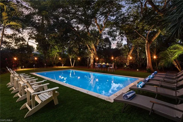 a view of a backyard with lawn chairs and a fire pit