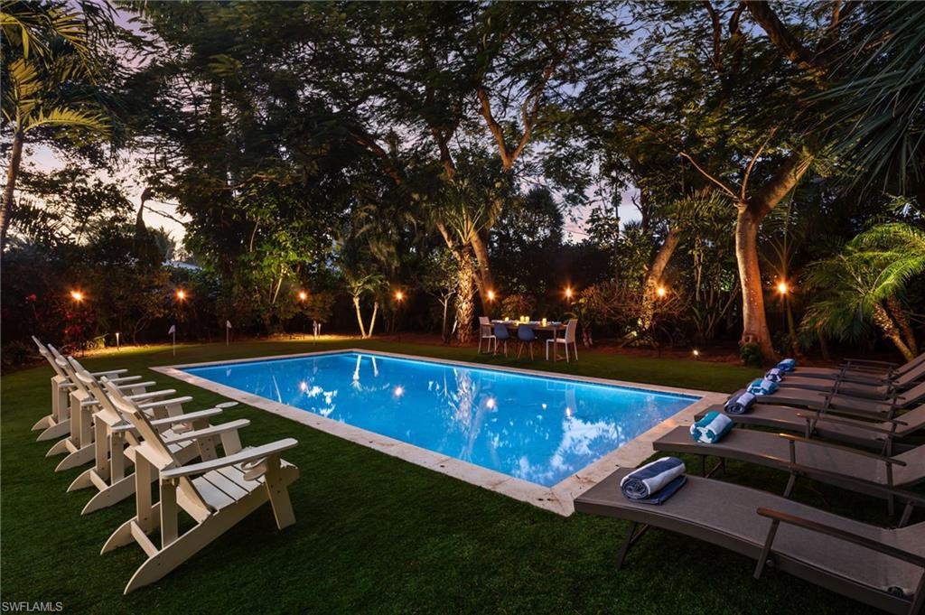 339 4th Avenue North Naples, FL 34102 - Photo 11 of 48 a view of a backyard with lawn chairs and a fire pit