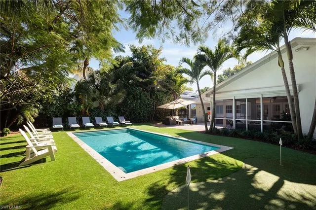 a view of a house with swimming pool and yard with green space