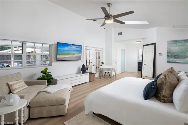 a bedroom with a bed a couch and a chandelier