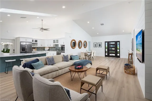 a living room with furniture kitchen view and a flat screen tv