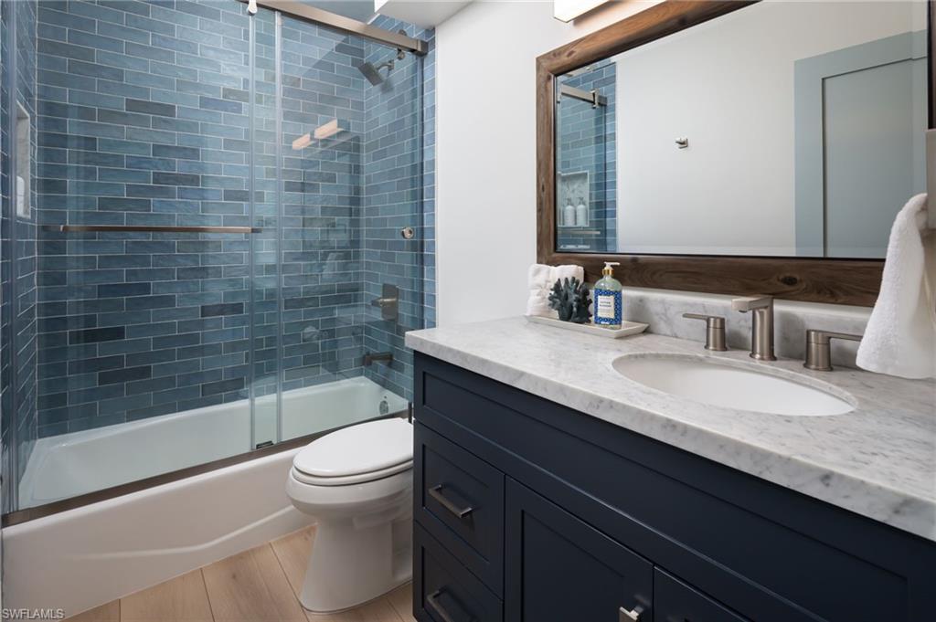 339 4th Avenue North Naples, FL 34102 - Photo 22 of 48 a bathroom with a granite countertop sink a toilet and shower