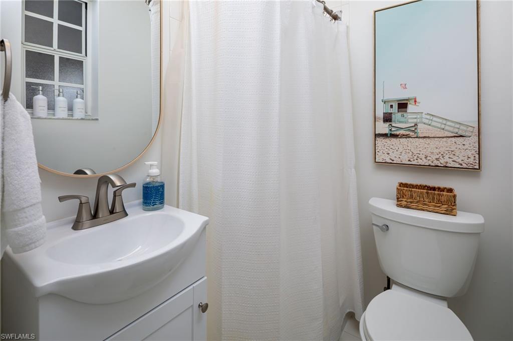339 4th Avenue North Naples, FL 34102 - Photo 23 of 48 a bathroom with a toilet sink and mirror