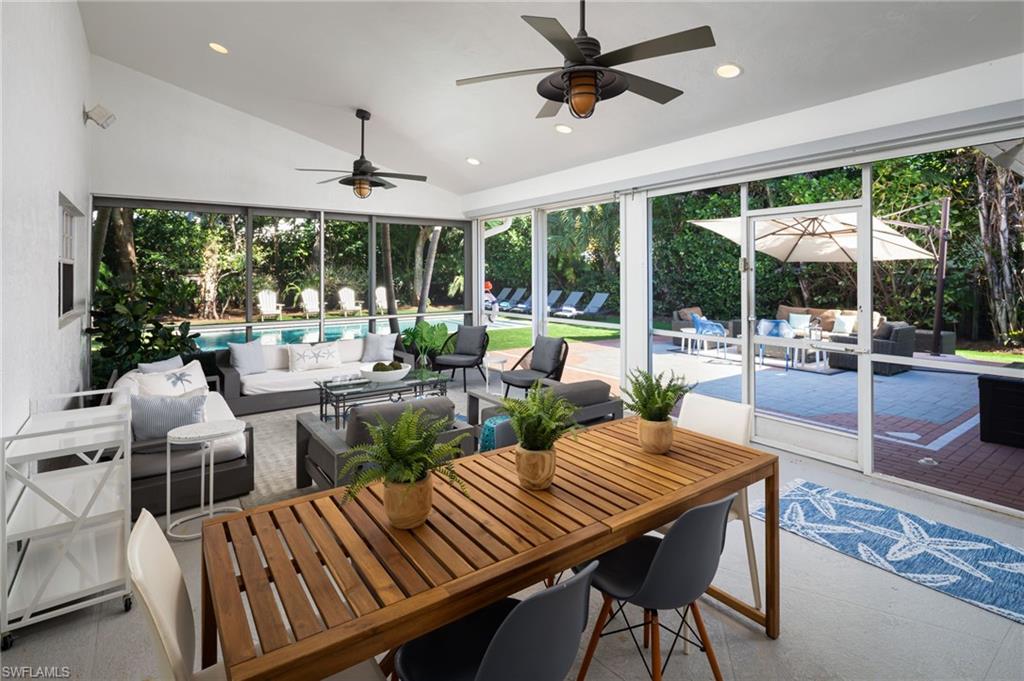 339 4th Avenue North Naples, FL 34102 - Photo 28 of 48 a view of a dining room with furniture large windows and wooden floor