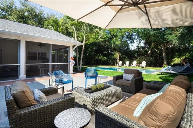 a view of a patio with couches chairs and a yard