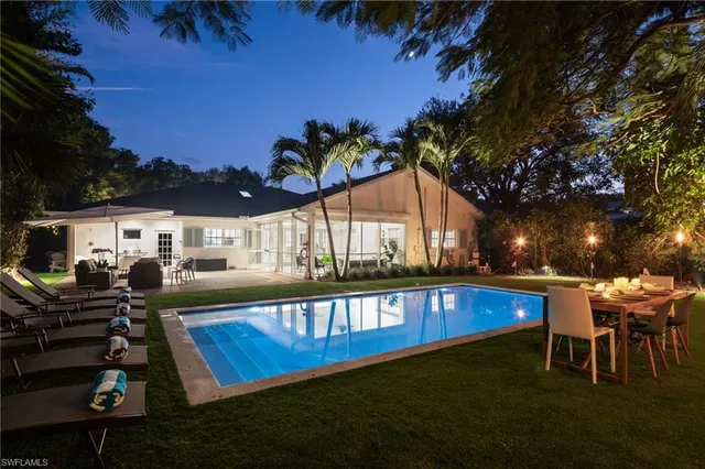 a view of a house with pool and chairs