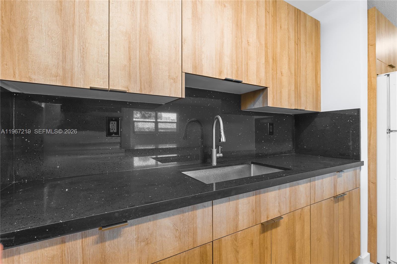 3265 Griffin Road, Unit 206 Dania Beach, FL 33312 - Photo 13 of 15 a kitchen with granite countertop a sink and a window