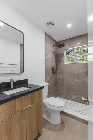 a bathroom with a granite countertop sink toilet and shower