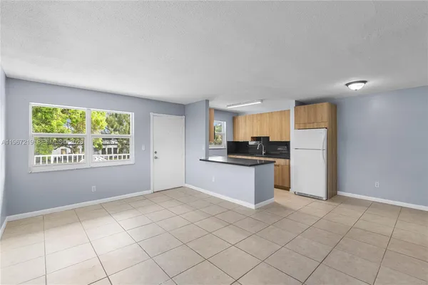 a large white kitchen with a stove a sink dishwasher and a refrigerator