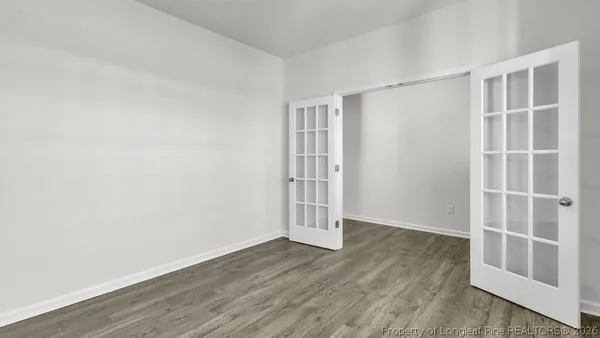 an empty room with wooden floor and empty shelves
