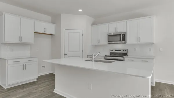 a kitchen with stainless steel appliances a sink a stove a microwave and cabinets