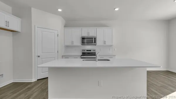 a kitchen with kitchen island a sink and a refrigerator