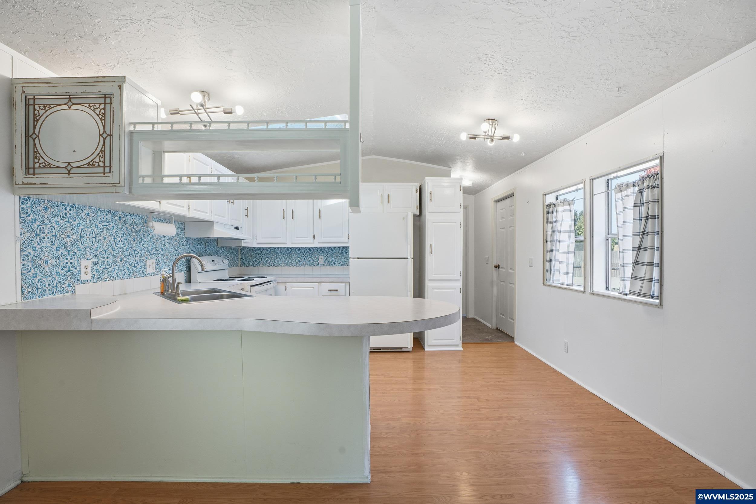 277 Edwards Road, Unit 145 Monmouth, OR 97361 - Photo 6 of 47 a kitchen with kitchen island a sink a stove and cabinets
