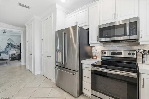 a kitchen with stainless steel appliances and white cabinets