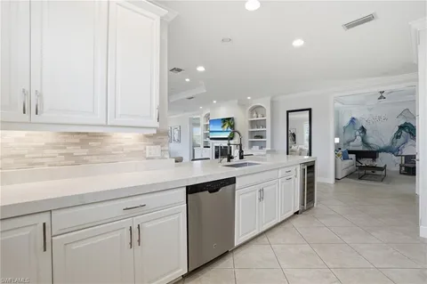 a kitchen with white cabinets and sink