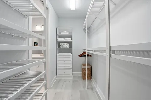 a view of walk in closet with clothes and shoes