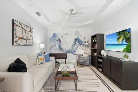 a living room with furniture and a painting on the wall