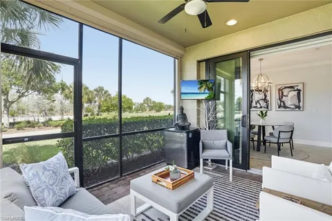 a living room with furniture and a floor to ceiling window