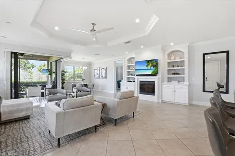 a living room with furniture a fireplace and a large window