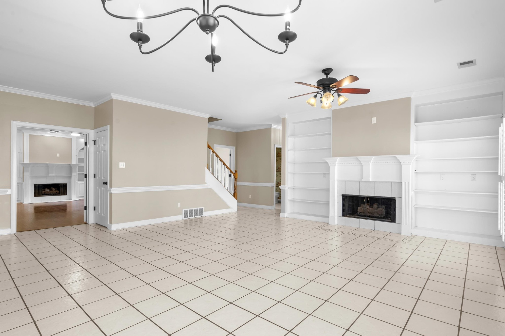 927 Oakmont Ridge Cove Collierville, TN 38017 - Photo 4 of 40 a view of an empty room with a fireplace and a chandelier fan